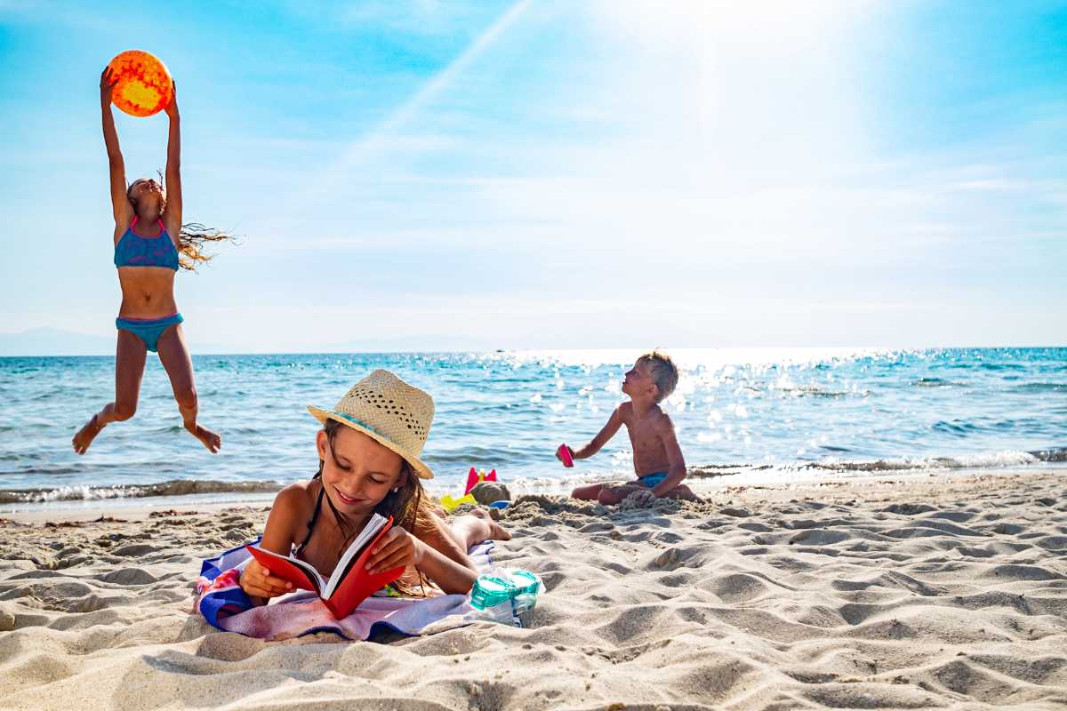 Vista panoramica del Golfo della Spezia con bambini che giocano sulla spiaggia