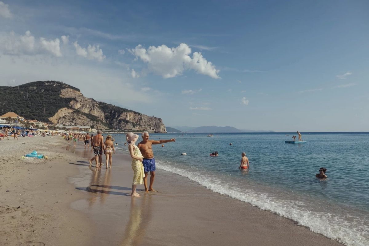 Spiaggia affollata di Finale Ligure con persone che si godono il sole