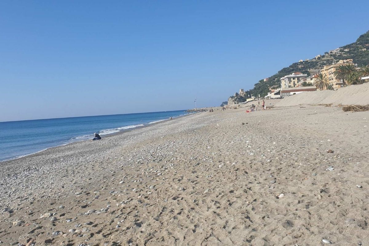 Vista panoramica della spiaggia di Finale Ligure, famiglie che si divertono sulla sabbia