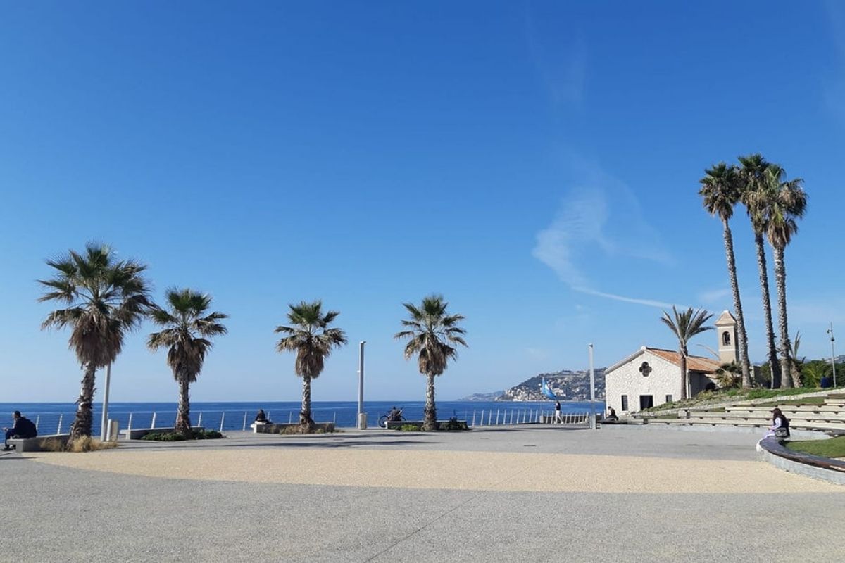 Lungomare di Bordighera al tramonto con ristoranti e palme
